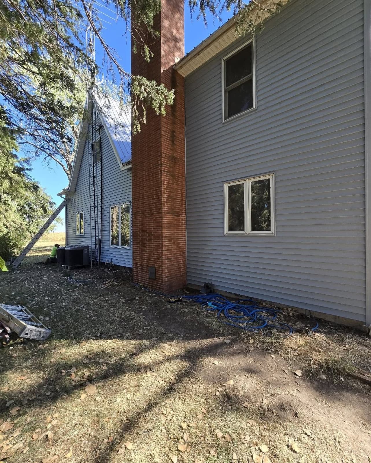 Cardona Company ladder set for a roof and chimney job on a two-story home