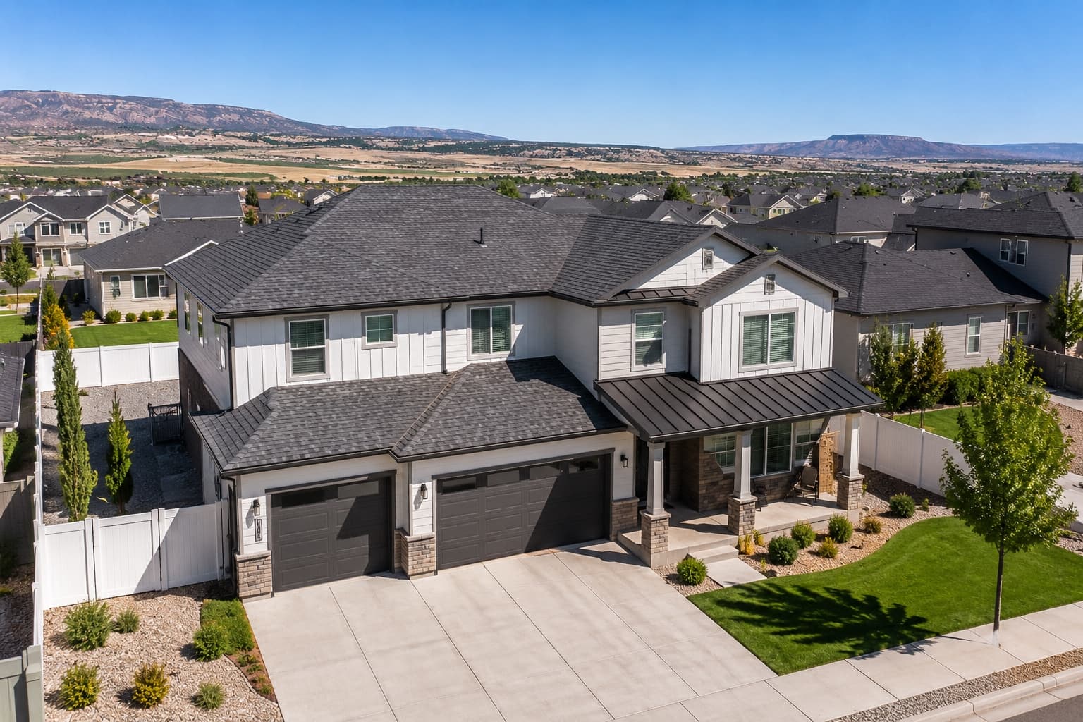 A completed Cardona Company roof on a two-story Southern Utah home framed by red-rock mesas